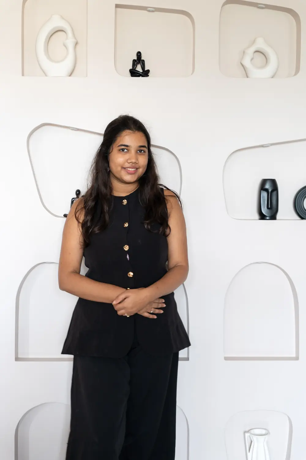 Mahek Vikmani standing in front of a wall of arched niches at The Alcove House